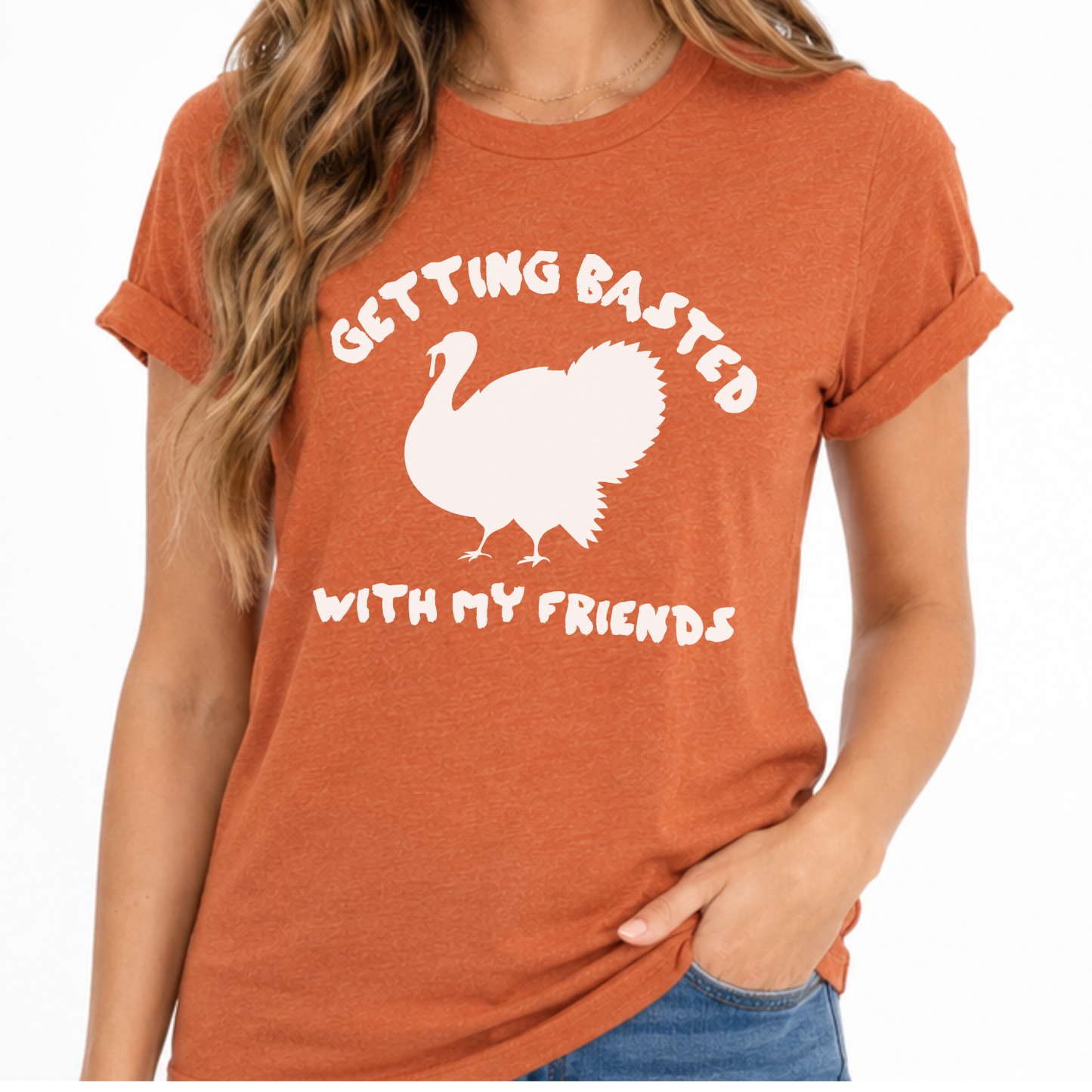 A woman wearing a heathered burnt orange t-shirt with a white graphic of a turkey and the text 'GETTING BASTED WITH MY FRIENDS'.