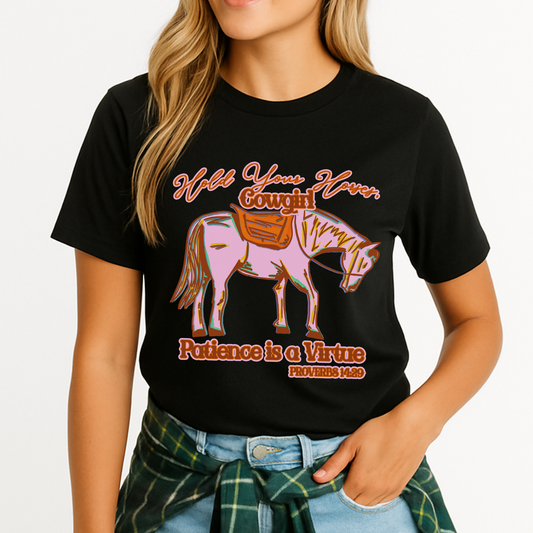 Woman wearing a  Bella Canvas graphic t-shirt featuring a colorful cowgirl horse illustration with the phrase “Hold Your Horses, Cowgirl” and “Patience is a Virtue Proverbs 14:29,” styled casually with jeans and coffee cup for a relaxed, western-inspired look.