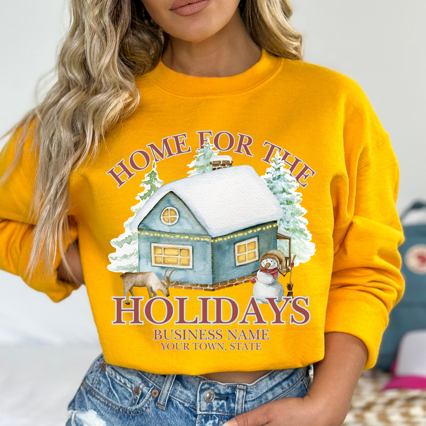 Home for the holidays yellow sweatshirt with graphics of a home in the snow, trees, snowman and a deer.  customize with business name, city and state or both