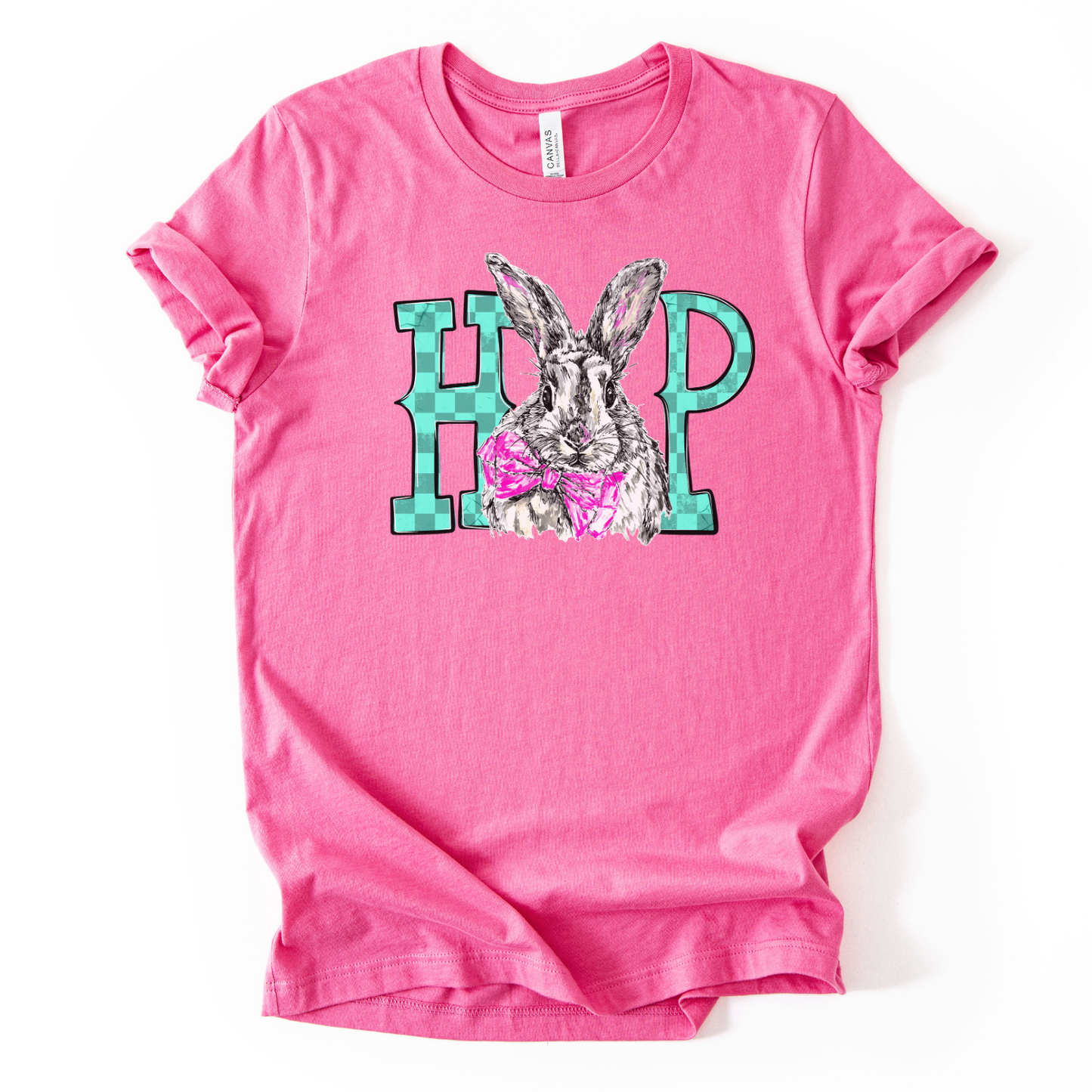A pink graphic t-shirt printed on a Bella Canvas® premium retail-fit tee.

The graphic features an illustrated bunny centered between bold block letters, wearing a pink bow tie for a playful Easter touch. The bunny illustration is detailed with soft sketch-style lines, while the surrounding lettering adds a clean, modern contrast. The overall design feels fun, lighthearted, and spring-ready, making it ideal for Easter celebrations and everyday seasonal wear.