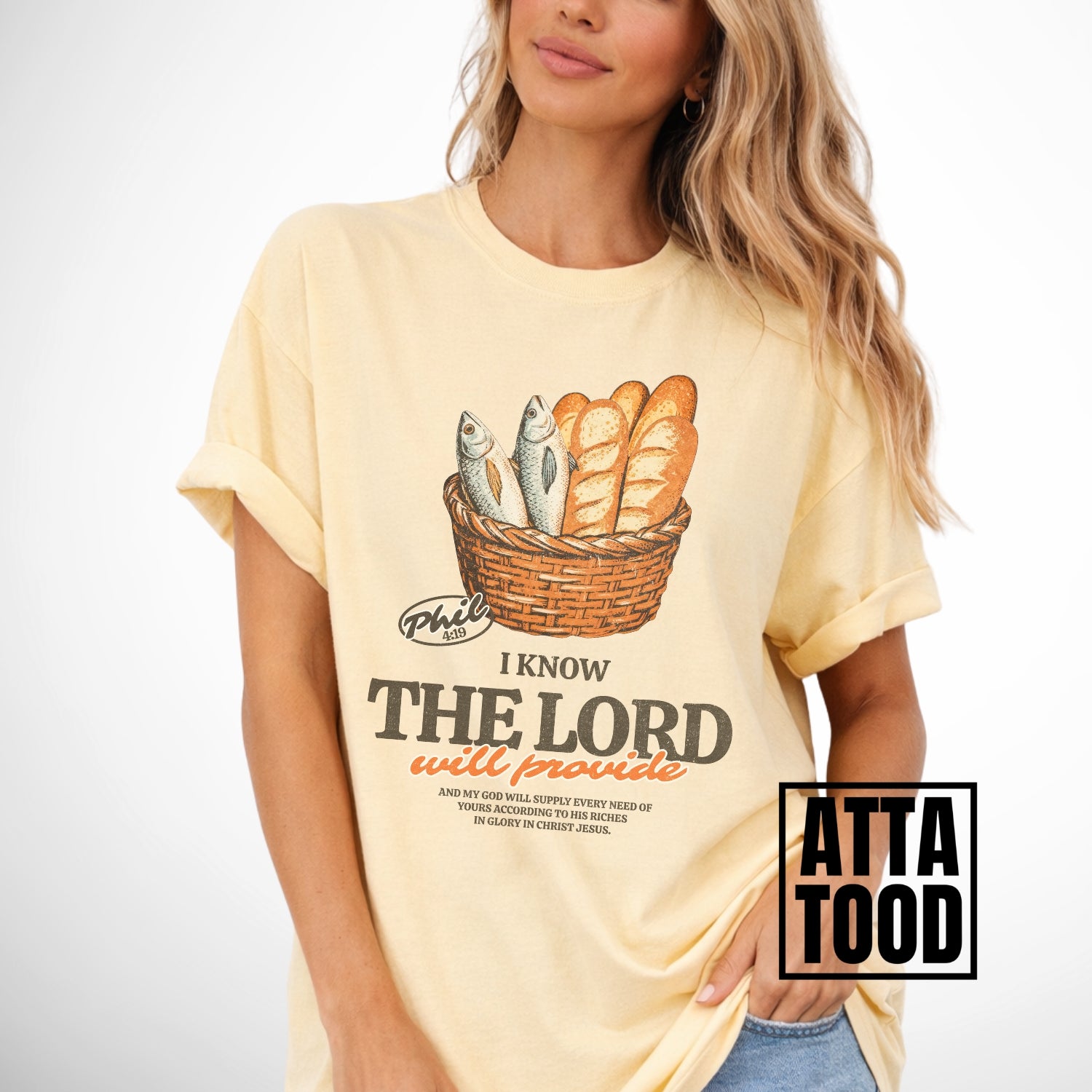 Person wearing a yellow t-shirt with a graphic design and text.  I know the Lord will provide featuring a basket of bread and fish referencing bible verse Philipians 4:19