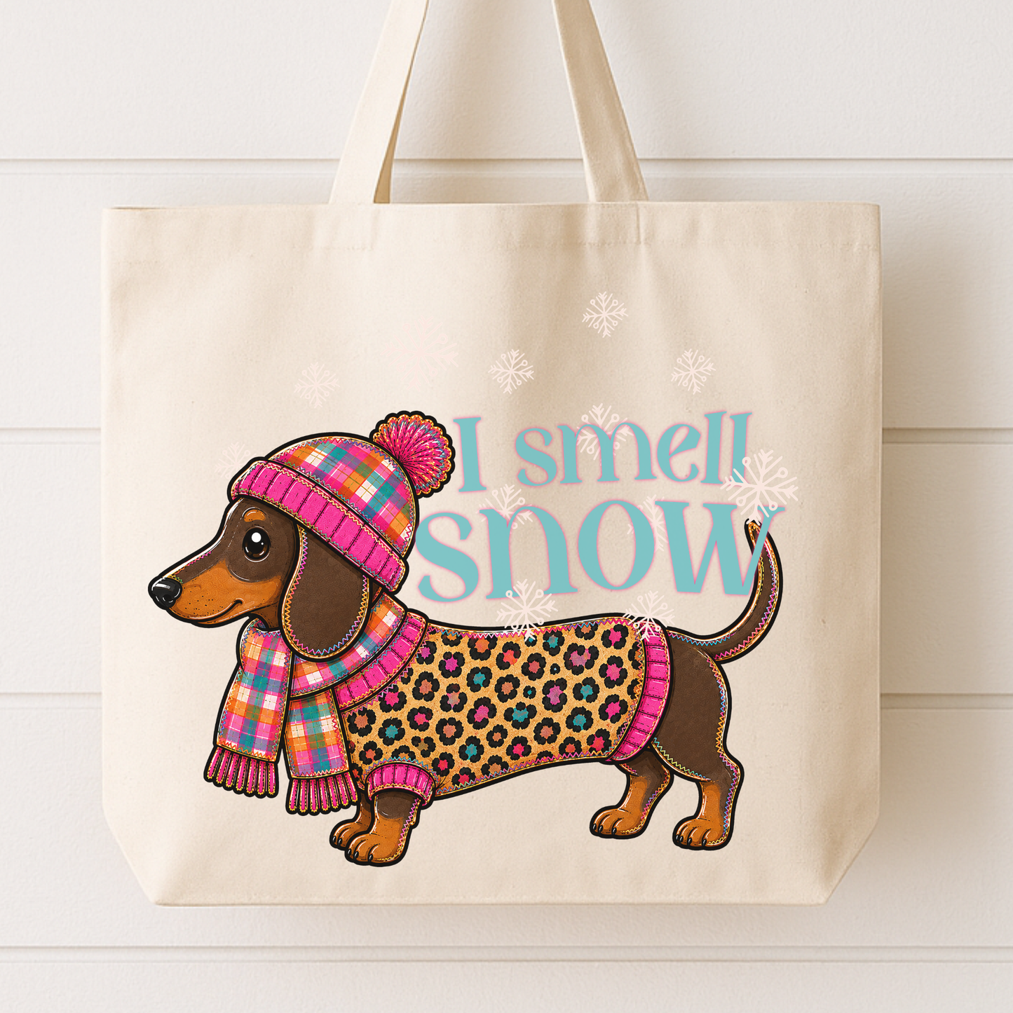 I smell snow with a cute little dachshund dog all bundled up in colorful leopard print sweater and plaid beanie and scarf. Design colors include Orange, Cream, Teal, Brown and Pink.