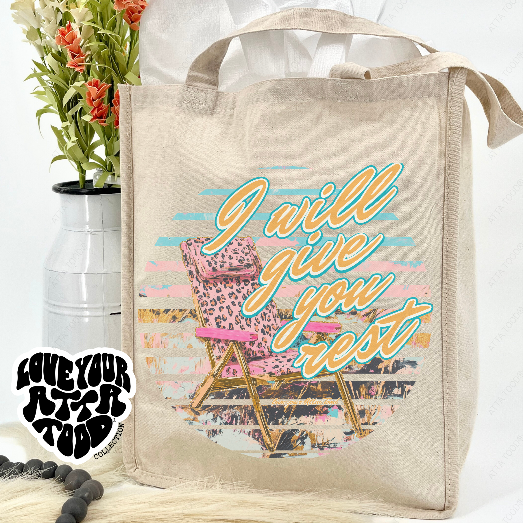 Beige tote bag with 'I will give you rest' design, pink chair, and flowers on a white background.