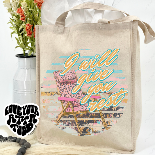 Beige tote bag with 'I will give you rest' design, pink chair, and flowers on a white background.