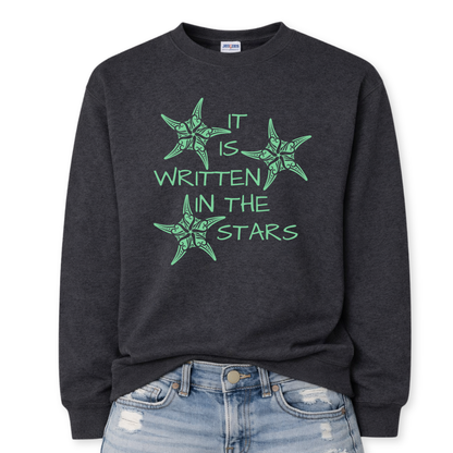 Heather black Coastal sea life graphic on a classic crewneck sweatshirt. The design features three decorative starfish illustrations arranged around the phrase It Is Written In The Stars. Each starfish contains detailed swirl and sea life pattern elements that create a textured coastal look