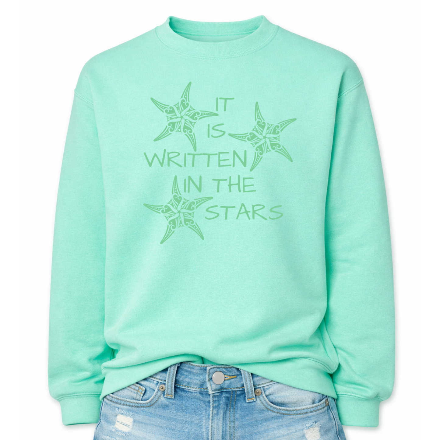 Mint Coastal sea life graphic on a classic crewneck sweatshirt. The design features three decorative starfish illustrations arranged around the phrase It Is Written In The Stars. Each starfish contains detailed swirl and sea life pattern elements that create a textured coastal look