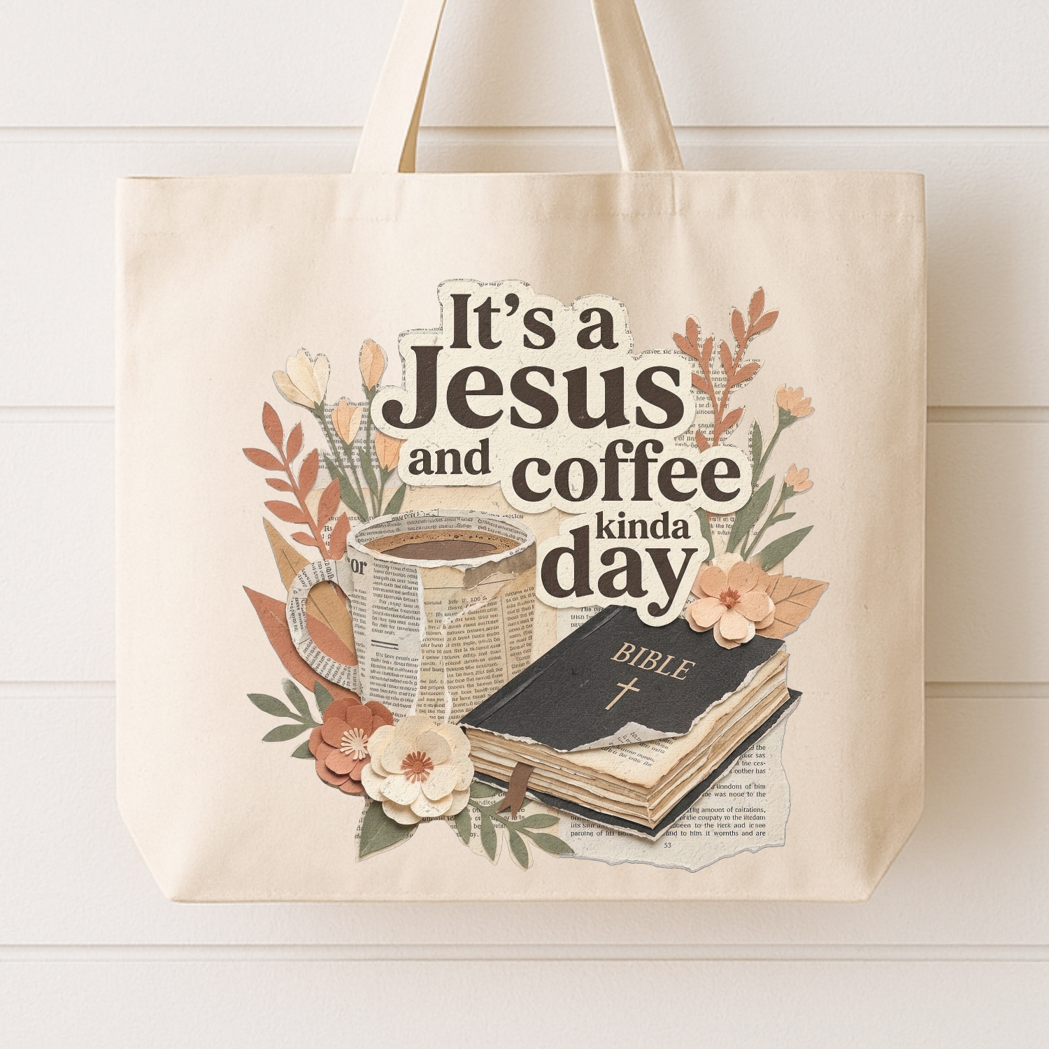 Beige tote bag with 'It's a Jesus and coffee kinda day' text, coffee cup, Bible, and flowers on a white background