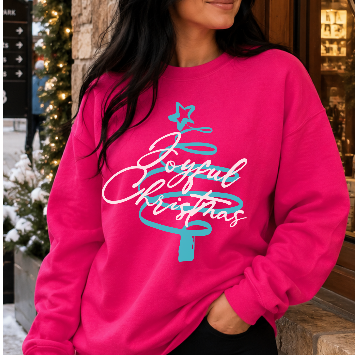 Joyful Christmas Tree Graphic Sweatshirt .  Turquoise Christmas tree with white lettering on a hot pink sweatshirt