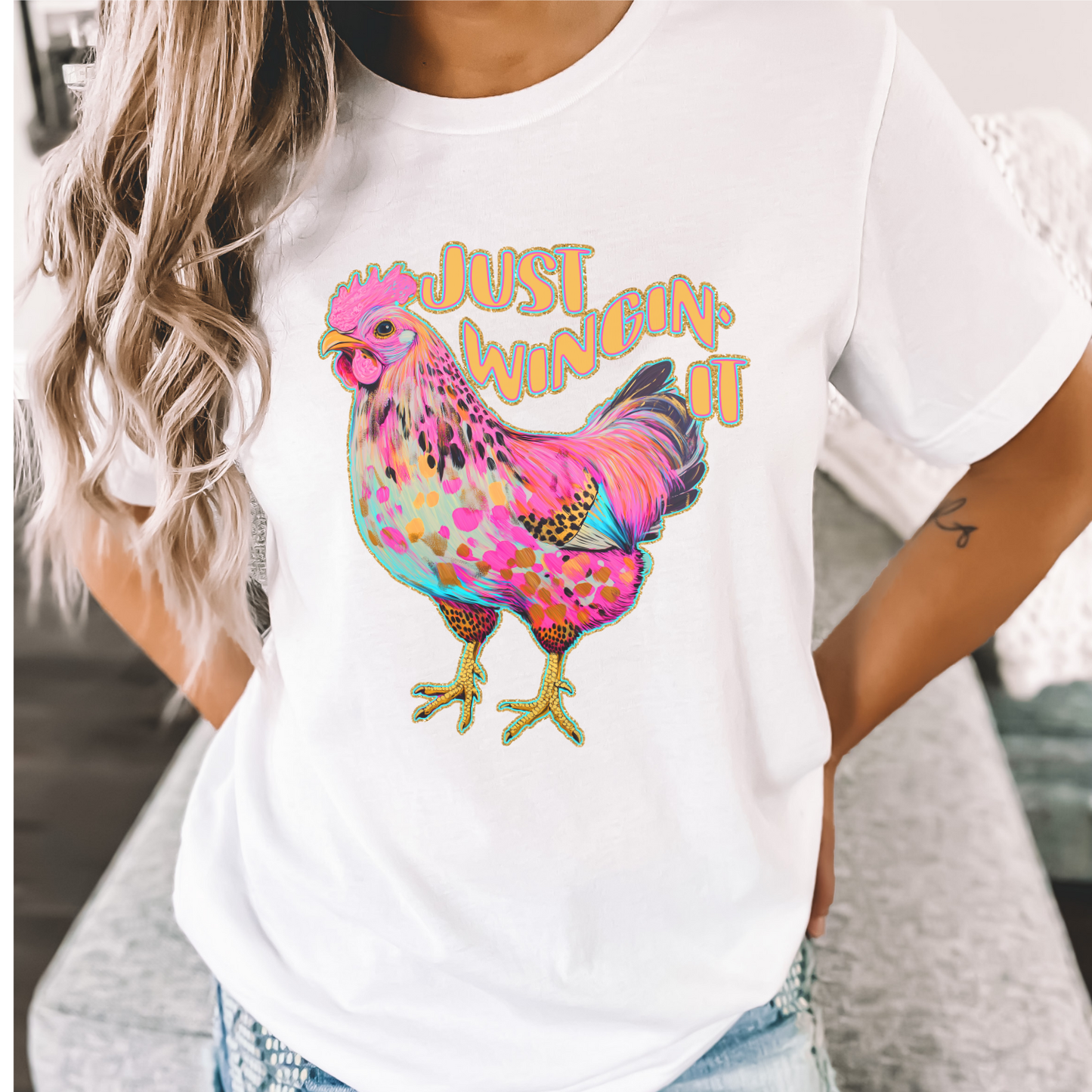 Person wearing a white t-shirt with a colorful chicken graphic and text.  Just wingin it