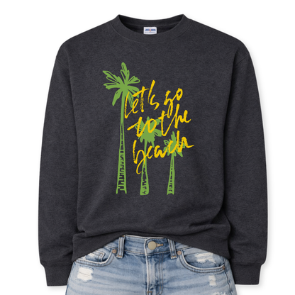 Tropical beach graphic on a classic dark heather gray crewneck sweatshirt. The design features three tall palm trees with the phrase Lets Go To The Beach layered across the center in a bold script style. The vertical palm tree layout creates a strong tropical silhouette that immediately communicates beach vacation style.