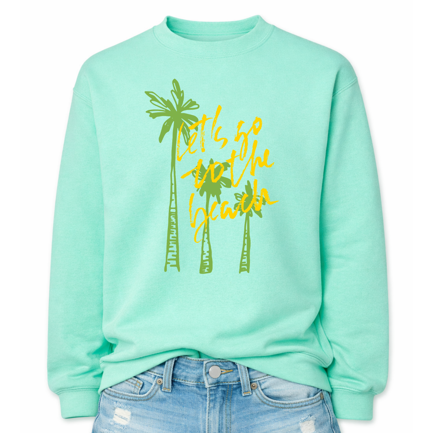 Tropical beach graphic on a classic mint green crewneck sweatshirt. The design features three tall palm trees with the phrase Lets Go To The Beach layered across the center in a bold script style. The vertical palm tree layout creates a strong tropical silhouette that immediately communicates beach vacation style.