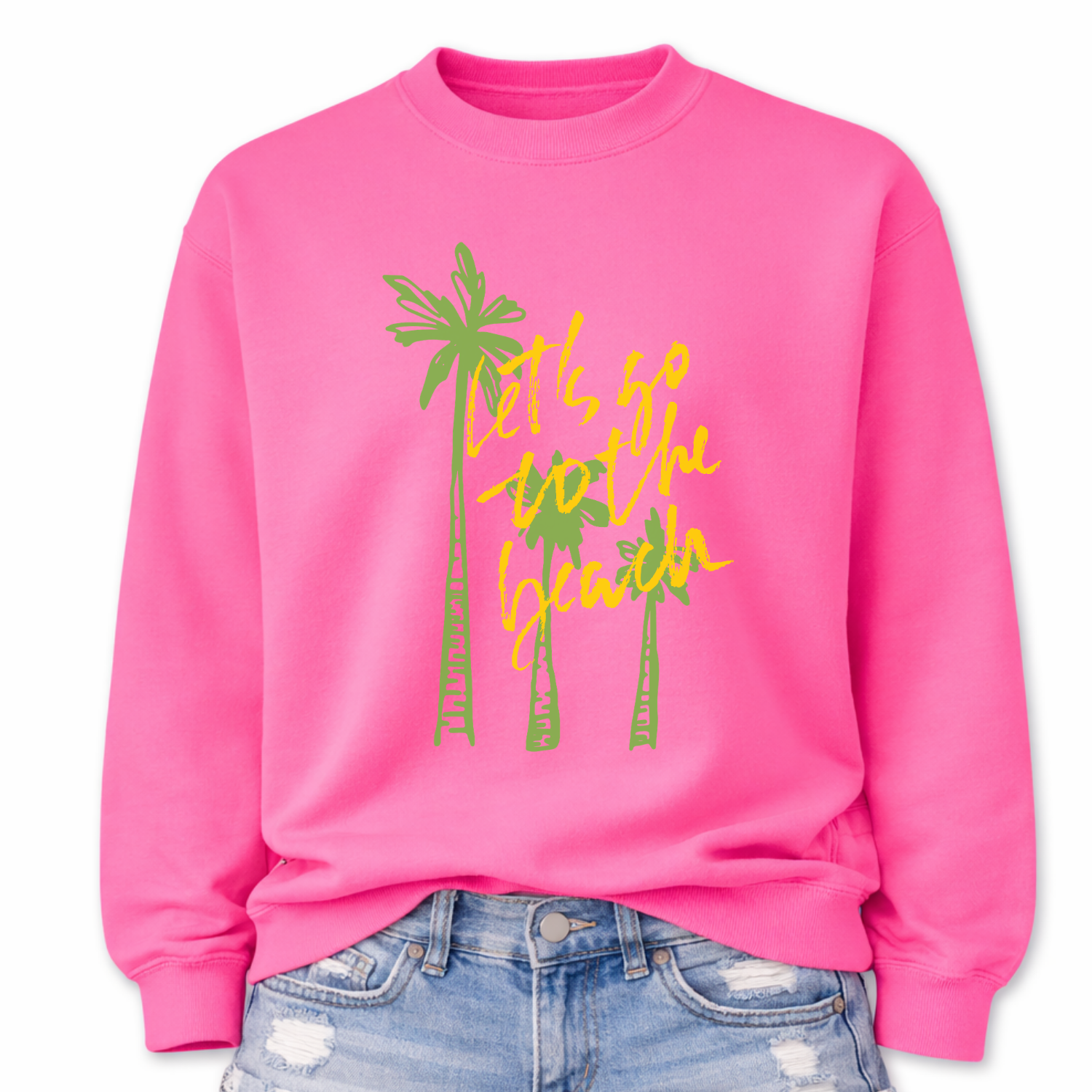 Tropical beach graphic on a classic pink crewneck sweatshirt. The design features three tall palm trees with the phrase Lets Go To The Beach layered across the center in a bold script style. The vertical palm tree layout creates a strong tropical silhouette that immediately communicates beach vacation style.