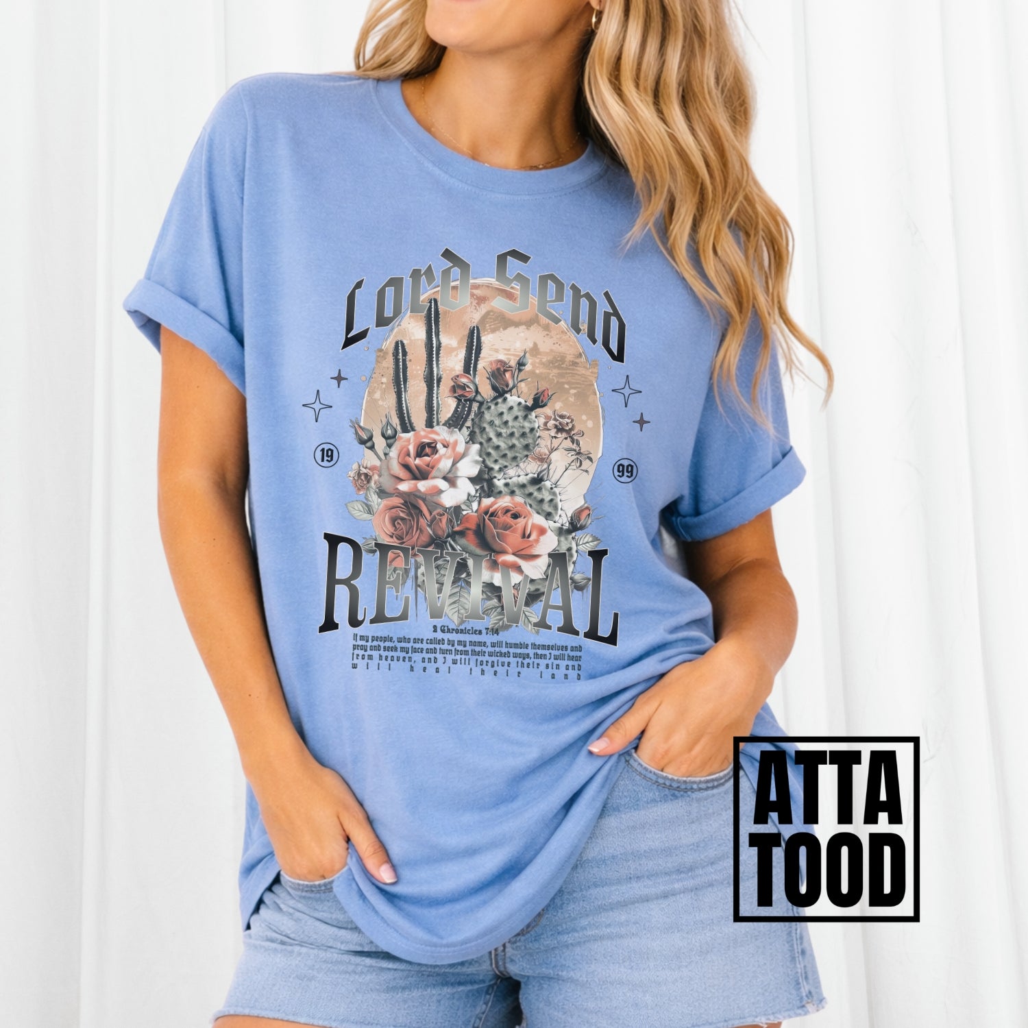 Woman wearing a blue t-shirt with a graphic design and text, standing against a white background. Lord Send revival featuring blooming cactuses