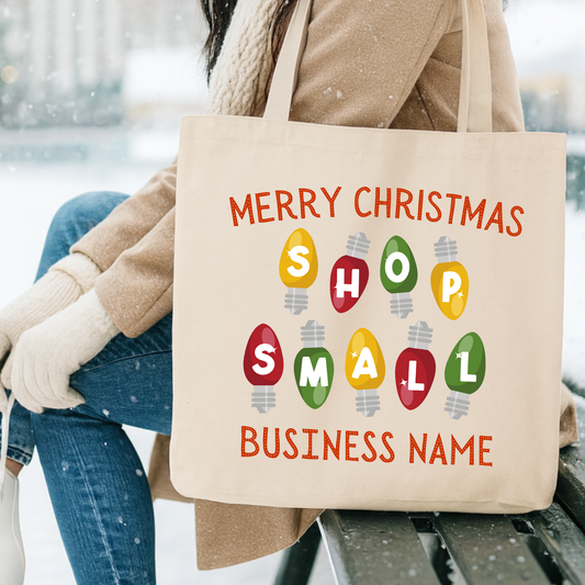 Tote bag with 'Merry Christmas Shop Small' text and colorful lights design. Customize tote with business name, city and state  or both.