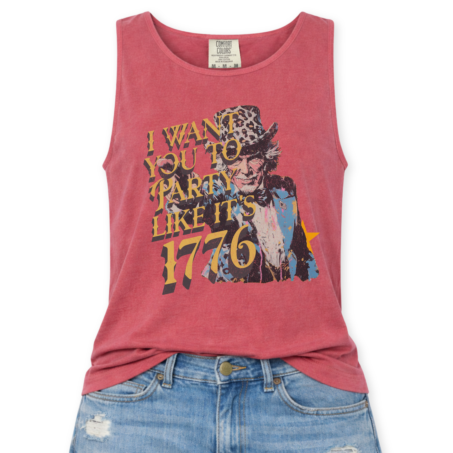 Crimson red Comfort Colors tank top featuring a distressed vintage Uncle Sam graphic with the phrase “I Want You To Party Like It’s 1776” in layered gold and dark lettering, styled in a flat lay mockup with light wash denim jeans.