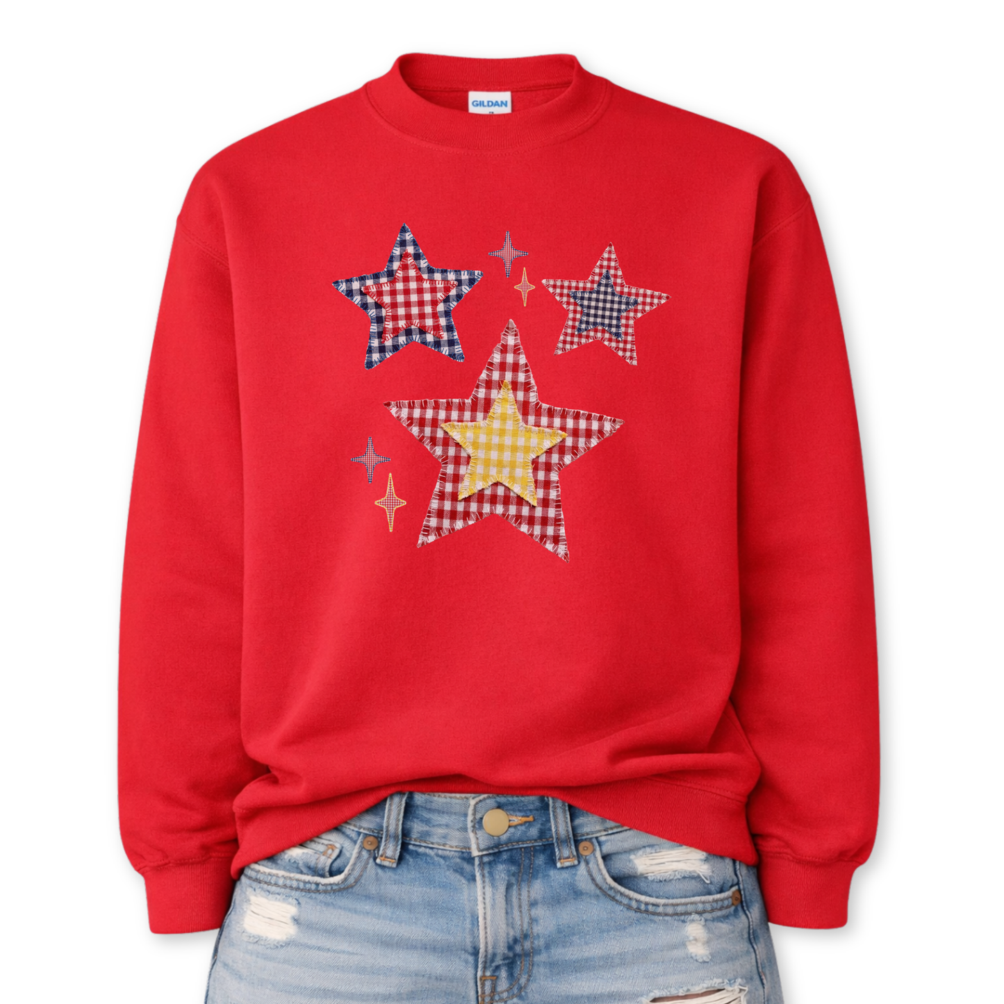 Patriotic patchwork star graphic on a red sweatshirt. The design features a cluster of illustrated stars in varied sizes, each filled with classic red, white, and blue gingham-style patterns, including plaid and check textures. Small accent sparkles add movement while the layered patchwork look gives the graphic a cozy, Americana feel. A versatile patriotic design ideal for Fourth of July, summer events, and seasonal USA collections.