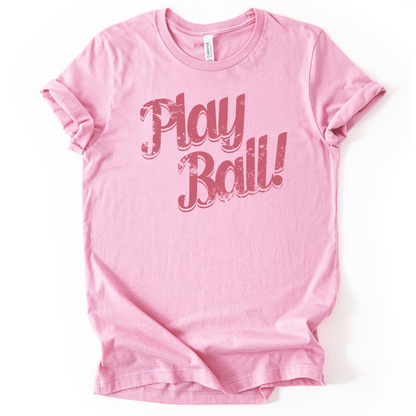 Pink t-shirt with 'Play Ball!' text on a white background