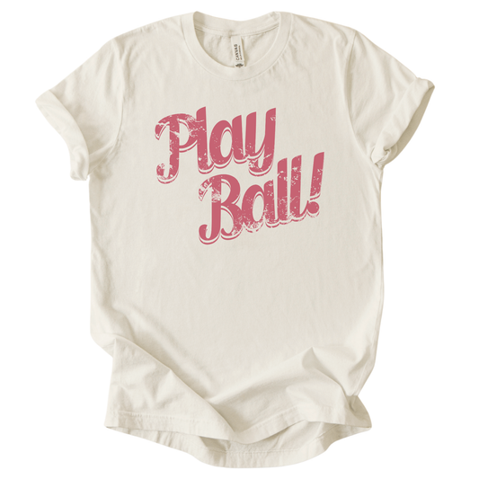 Cream t-shirt with 'Play Ball!' text in pink on a white background