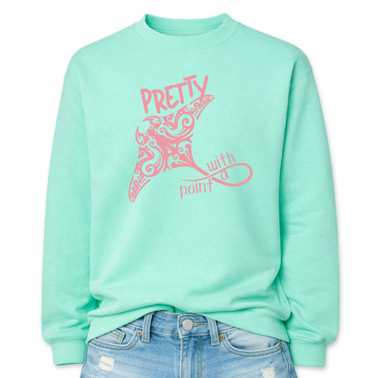 Coastal sea life graphic on a classic mint green crewneck sweatshirt. The design features a large manta ray illustration filled with decorative swirl and coastal pattern details that create a textured ocean inspired look. The phrase Pretty With A Point is integrated with the graphic, with bold lettering above the manta ray and flowing script below, forming a balanced sea life layout that reads clearly from a distance.