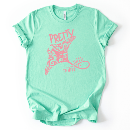 Coastal ocean graphic on a soft unisex mint green graphic tee. The design features a large manta ray illustration filled with decorative swirl and coastal pattern details that give the sea life artwork a textured, ocean inspired look. The phrase Pretty With A Point appears integrated into the graphic, with bold lettering above the manta ray and flowing script below, creating a balanced coastal themed layout.
