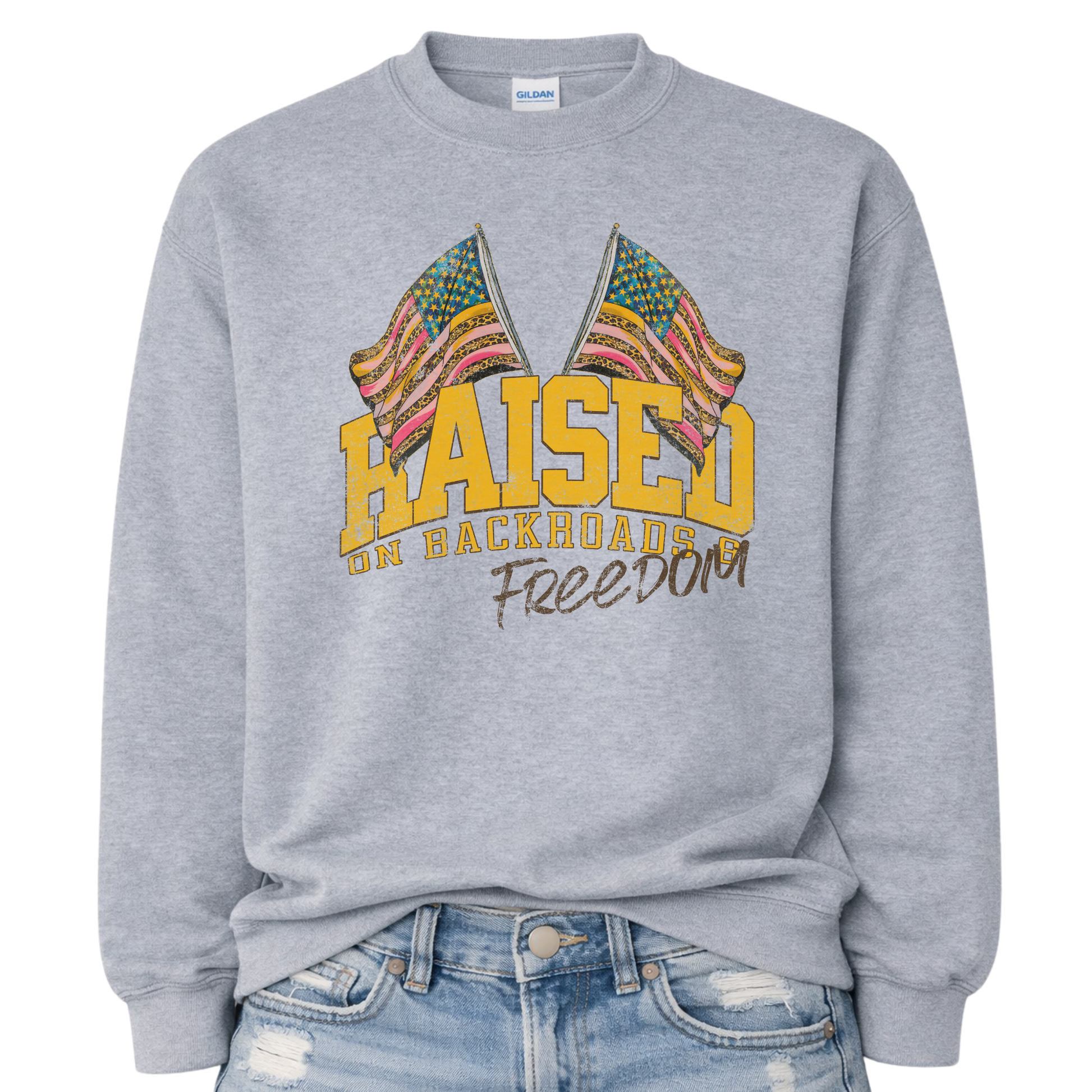 Gray sweatshirt with colorful flag design and text 'Raised on Backroads Freedom' on a white background.