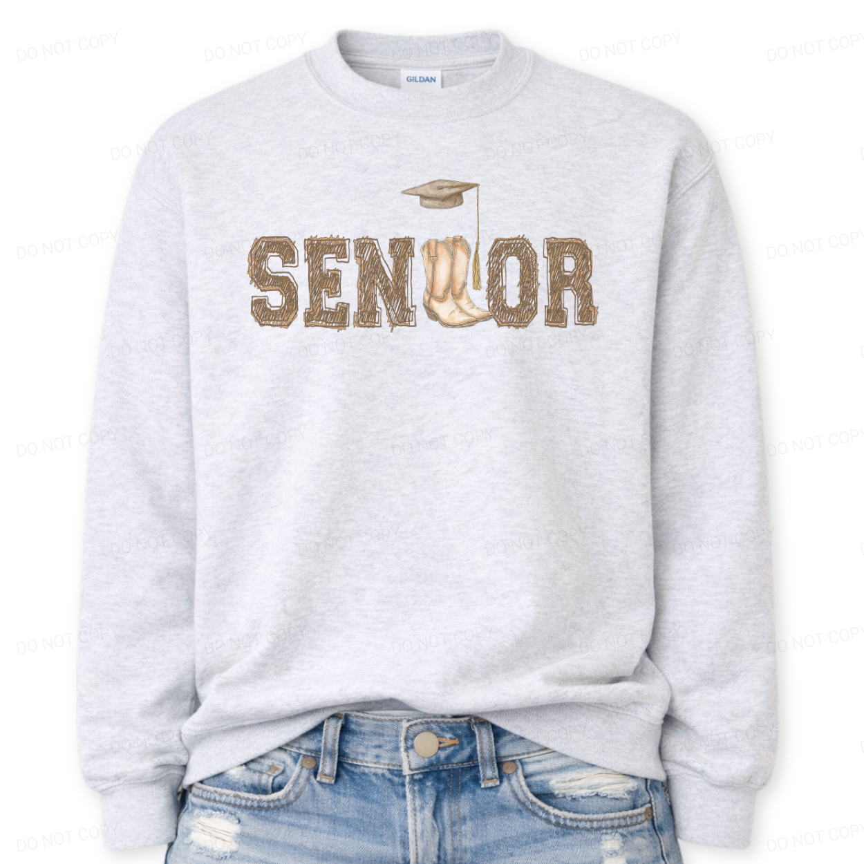 Western graduation graphic on a classic ash crewneck sweatshirt. The design features SENIOR in bold varsity style lettering with a pair of cowboy boots integrated into the wordmark and a small graduation cap detail above,
