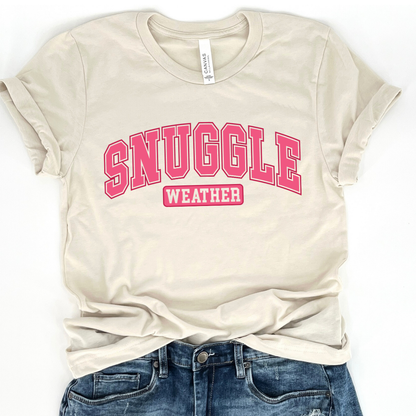 snuggle weather pink graphic on a heather oatmeal t-shirt