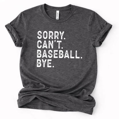 Dark heather gray graphic t-shirt with distressed white text that reads “SORRY. CAN’T. BASEBALL. BYE.” laid flat with rolled sleeves.
