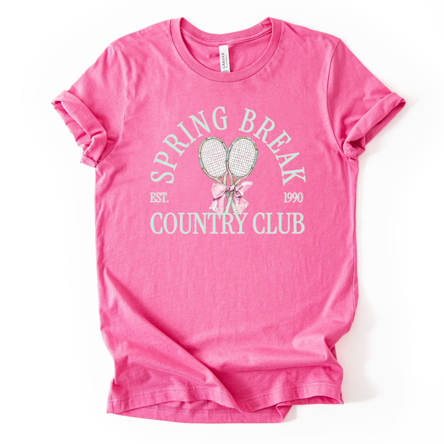 Pink t-shirt with 'Spring Break Country Club' text and graphics on a white background.The graphic features a pair of illustrated tennis rackets crossed at the handles and tied together with a soft pink ribbon bow at the center. Arched text reads “Spring Break Country Club”, with small accent details adding a classic, collegiate feel. The design blends sporty tennis elements with preppy spring style, making it ideal for seasonal tennis displays and everyday lifestyle wear.