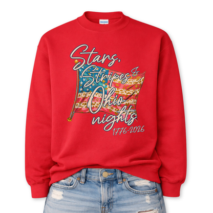 Patriotic stars and stripes graphic on a red sweatshirt. The artwork shows a waving American flag with stars, striped details, and leopard-print accents, paired with script lettering that reads “Stars, Stripes & ___ Nights” plus “1776–2026” for a bold Fourth of July and summer patriotic look. Customizable location option: add any City or State (up to 30 characters) to make it a hometown, vacation spot, or event-ready USA piece.