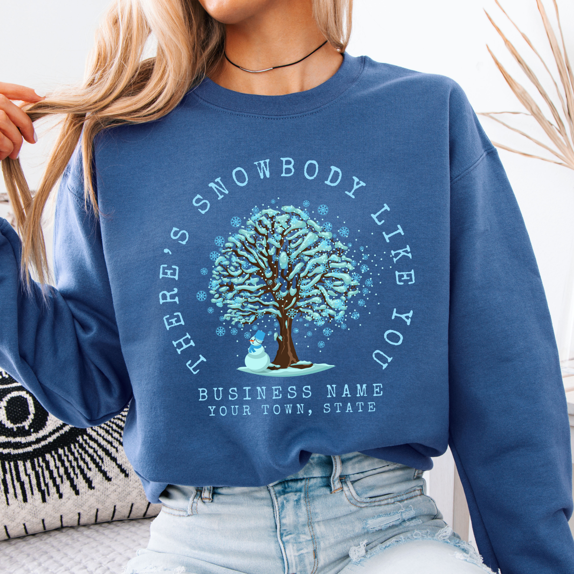 There's snowbody like you text wrapped around a tree with branches full of blue snow and a snowman underneath.  customize with business name, city or town or both.  blue sweatshirt