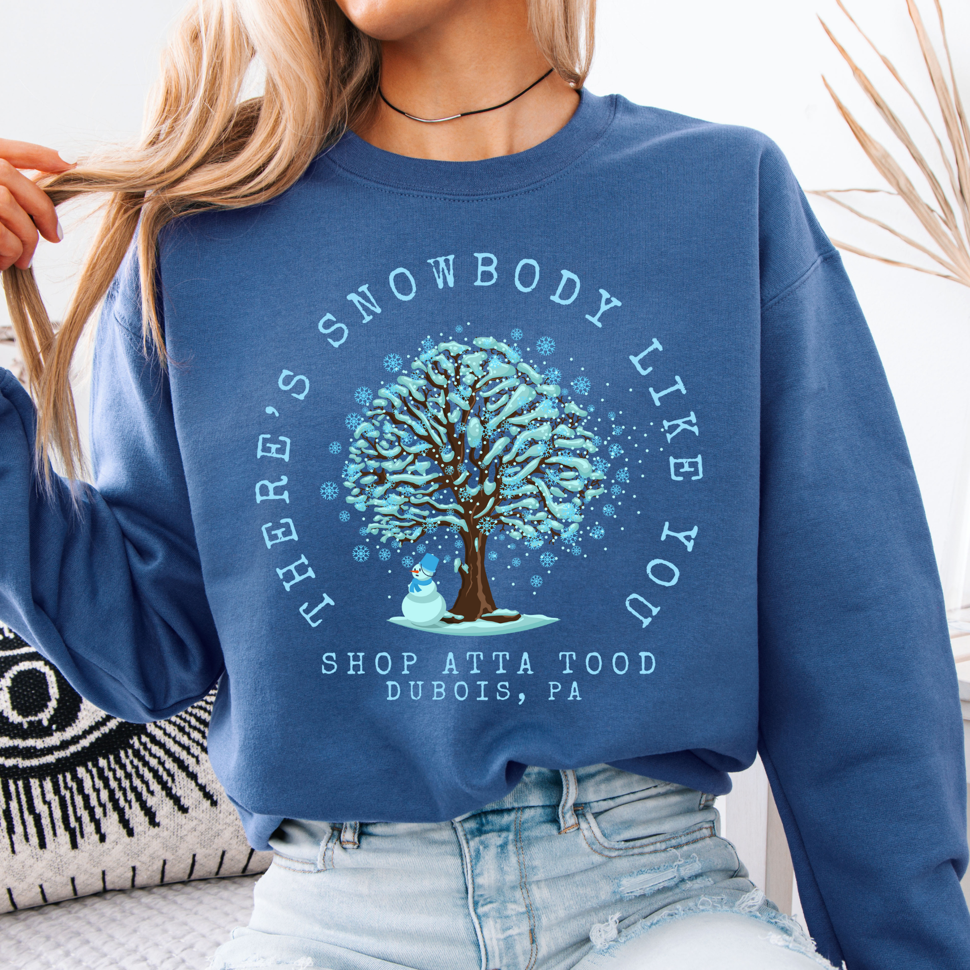 There's snowbody like you text wrapped around a tree with branches full of blue snow and a snowman underneath.  customize with business name, city or town or both.  blue sweatshirt