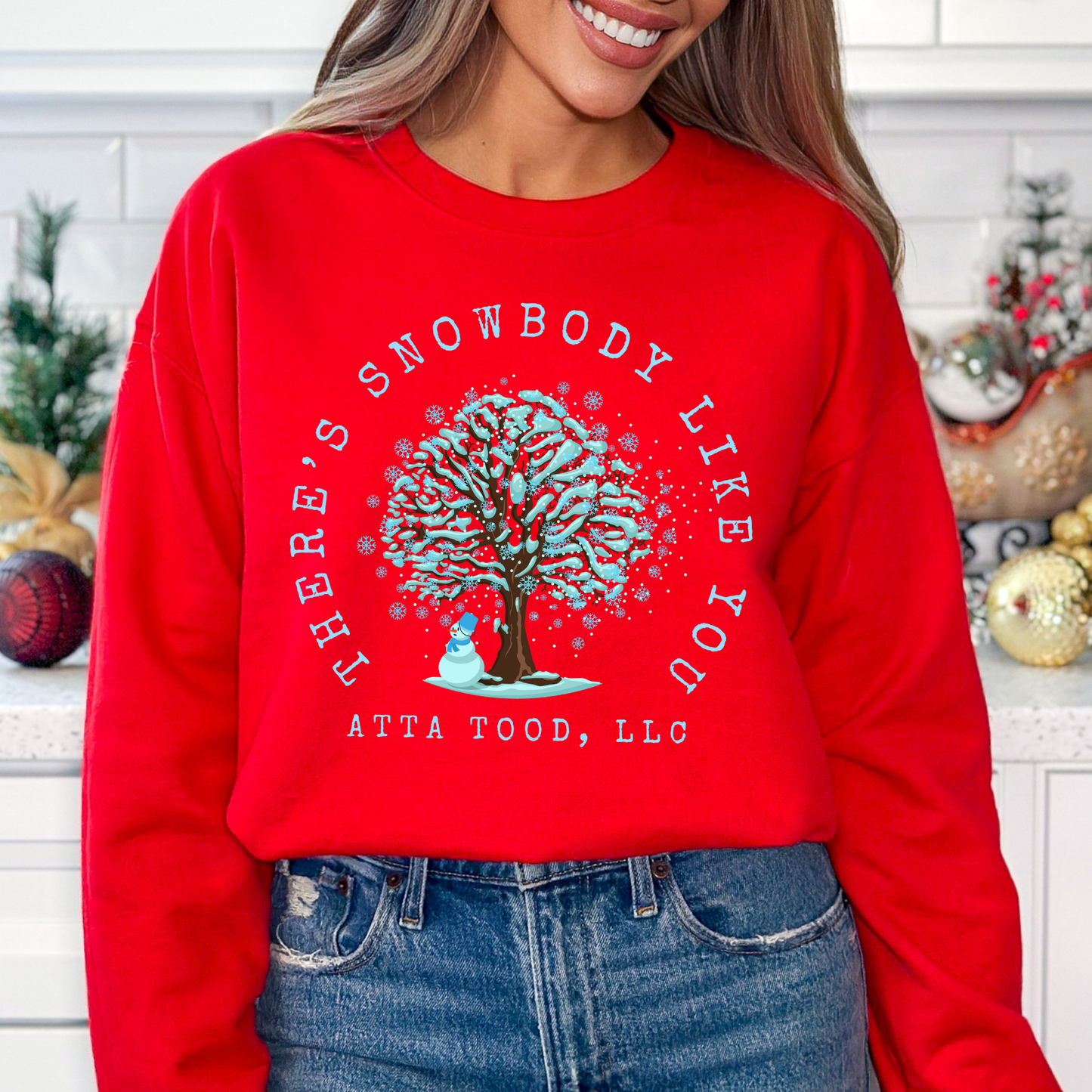 There's snowbody like you text wrapped around a tree with branches full of blue snow and a snowman underneath.  customize with business name, city or town or both.  red sweatshirt