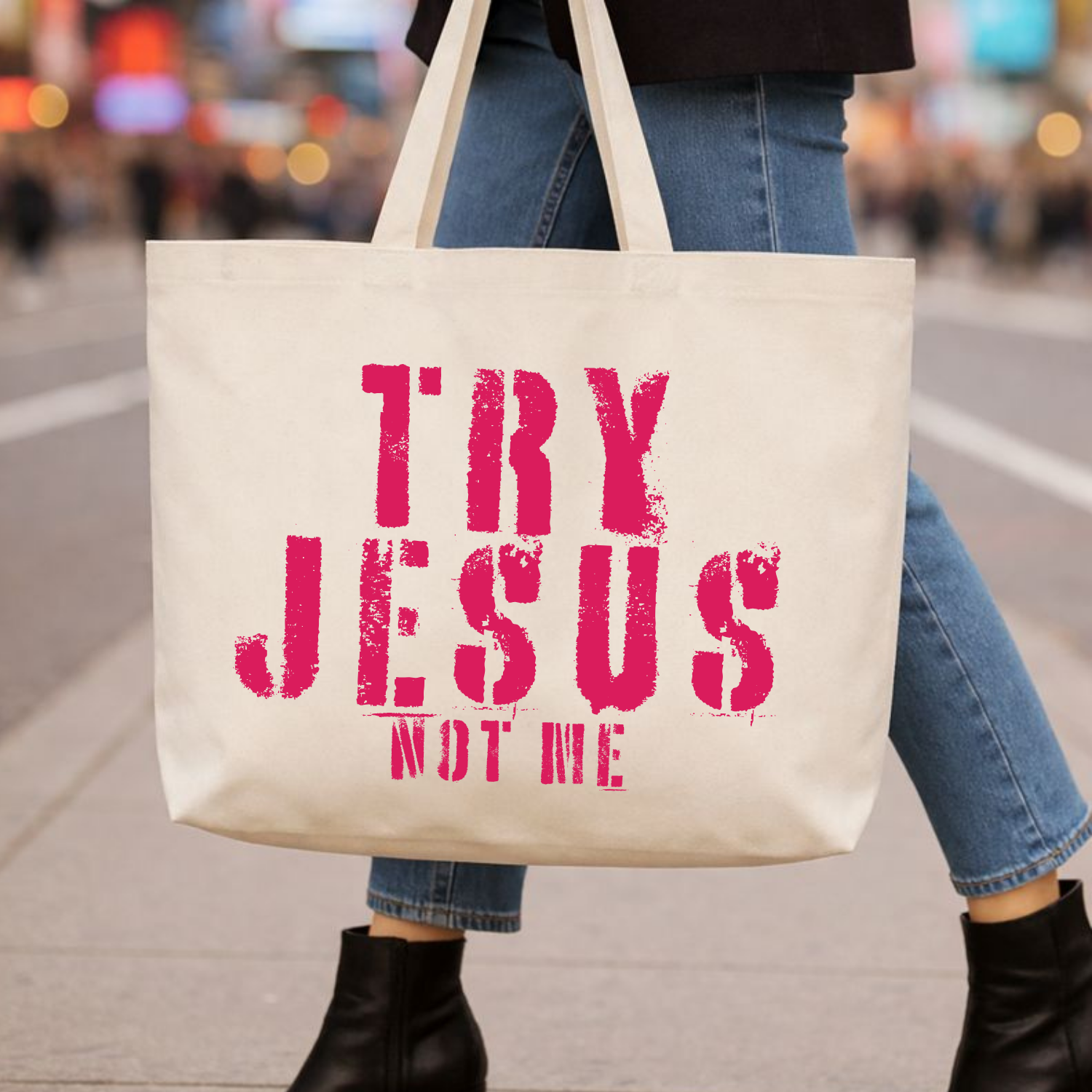 Natural cotton canvas tote bag with distressed pink stencil-style lettering reading “Try Jesus Not Me,” hanging against a white shiplap wall; reusable canvas tote with a bold, faith-forward, sarcastic message.