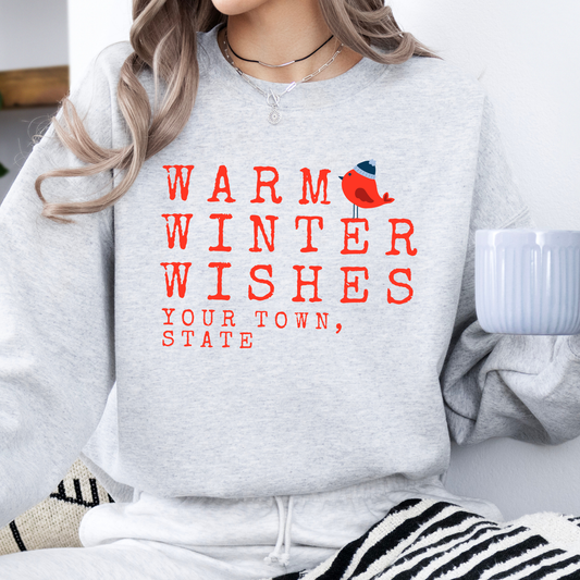 Warm winter wishes written in red with a little red bird wearing a blue beanie hat.  Gray sweatshirt.  Customize with business name, zip code, town, state or all. 