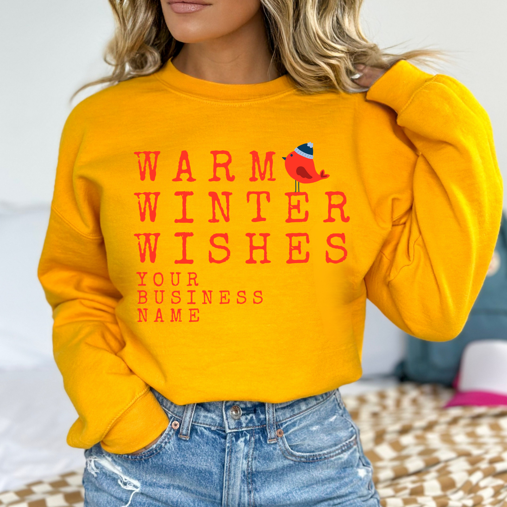 Warm winter wishes written in red with a little red bird wearing a blue beanie hat.  Gold sweatshirt.  Customize with business name, zip code, town, state or all. 